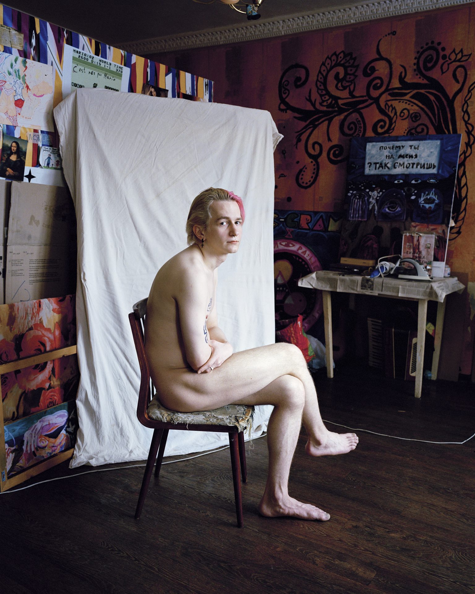 Young man sitting on a chair in a painted room