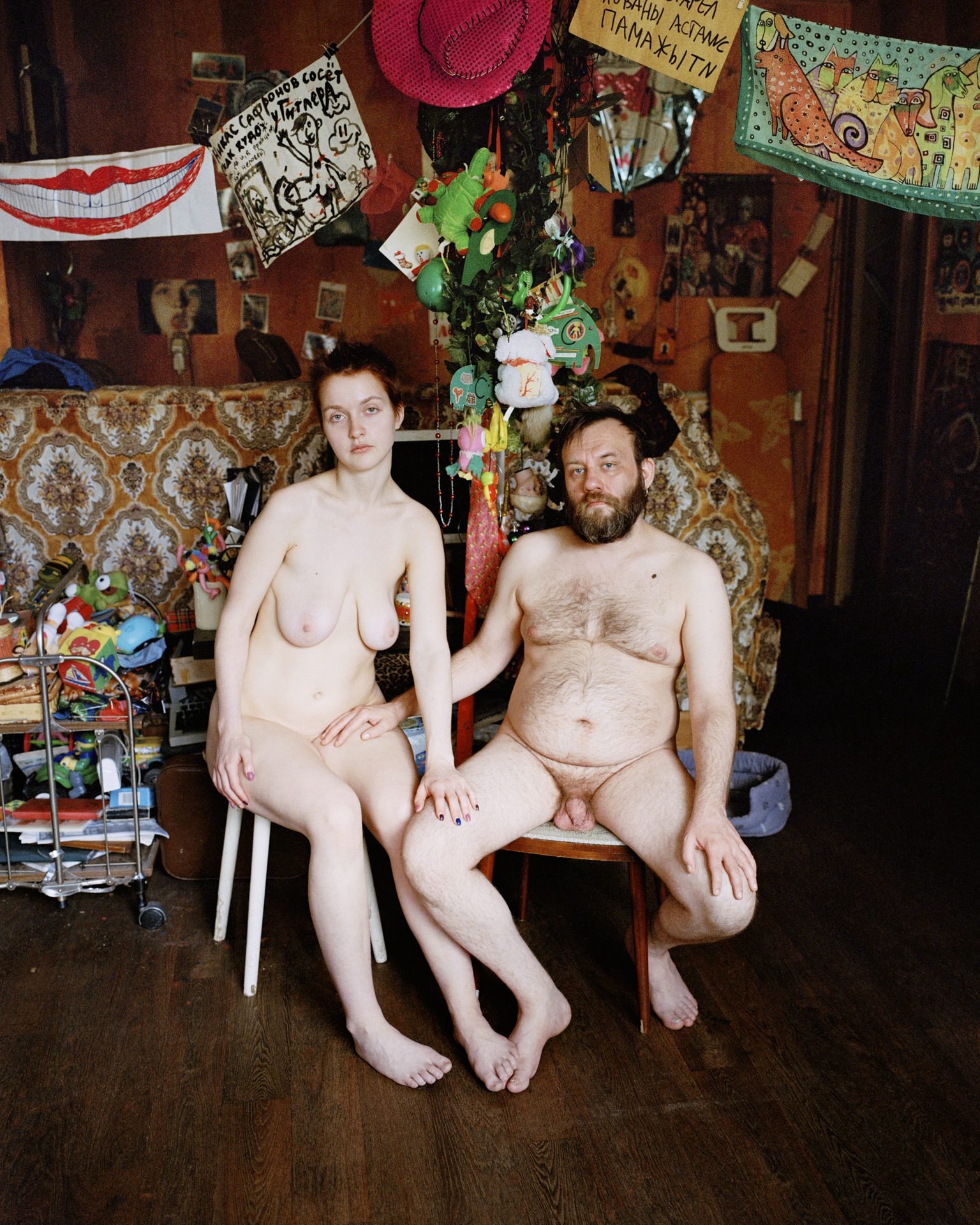 Couple sitting in a room hung with drawings